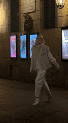 Night scene on a Milan sidewalk, figure in white at center