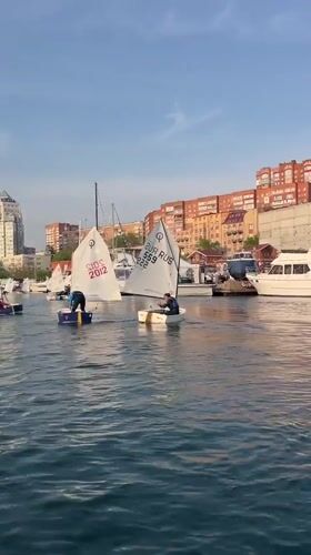 Sailboats navigate Vladivostok harbor on sunny morning