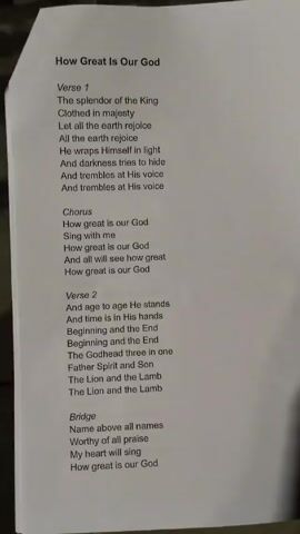 The video shows a printed lyric sheet for the song "How Great Is Our God." The sheet includes verses, a chorus, and a bridge. A faint drum beat can be heard.