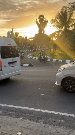 Evening traffic flows past Garuda Wisnu Kencana statue in Bali