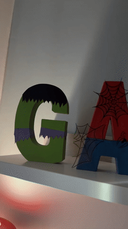 Superhero-themed wooden letters spell "GABRIEL" on Luxembourg shelf