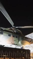 Camouflaged military helicopter on display at night, Cibinong