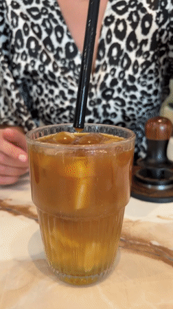 Woman prepares drinks at Budva cafe counter