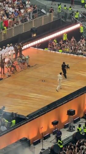 Packed London stadium concert, brass band, big screens, full house