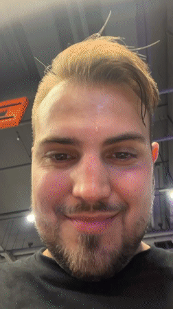 Bearded man waves at camera inside Moscow gym