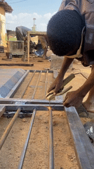 Metal workers weld gates in outdoor workshop, Nigeria