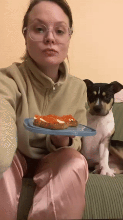 Woman in pajamas enjoys meal on couch in Tel Aviv