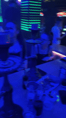 Club scene captured with neon lights and hookah visible