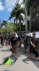 Men in traditional sarongs walk sunny Kuta Selatan street