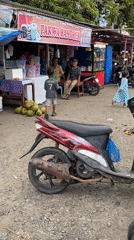 Street market morning: grilled skewers, clothing stalls, and scooters
