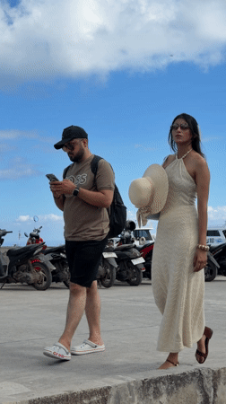 Two people walk coastal area in Nusa Penida, Indonesia