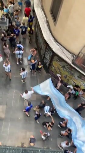 Argentine fans fill a Barcelona alley, police nearby
