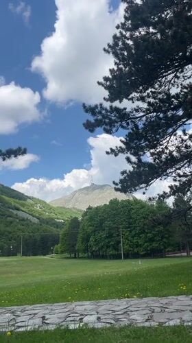 Mountain picnic gathering observed amid distant forest smoke Montenegro