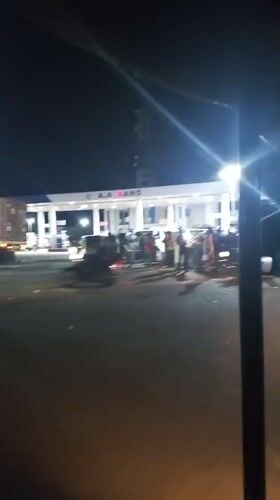 Crowd gathers at Lokoja gas station with vehicles present