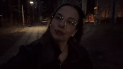 Woman walks on lit pathway in Ust-Ilimsk, Russia