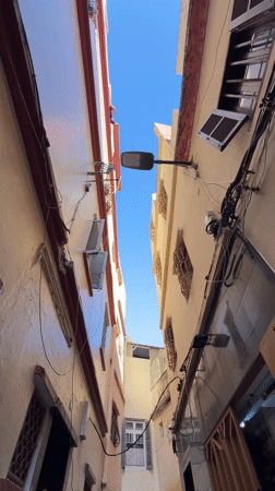 Person poses with street art backdrop in Tangier