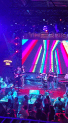 Live band performs to crowded audience with LED visuals