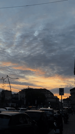 Dramatic sunset illuminates Milan street scene Tuesday evening