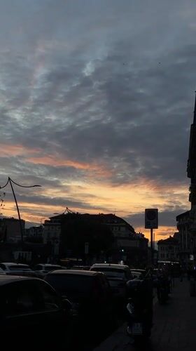 Dramatic sunset illuminates Milan street scene Tuesday evening