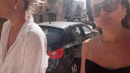 Two women walk down sunny Cannes street