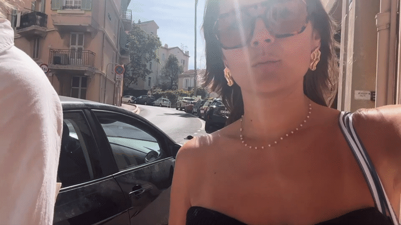 Two women walk down sunny Cannes street