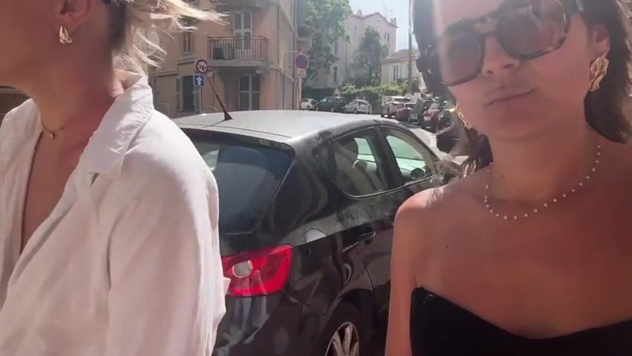 Two women walk down sunny Cannes street