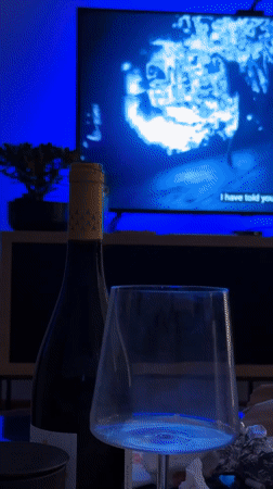 Woman records evening selfies in dim Belgrade room