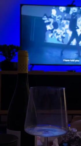 Woman records evening selfies in dim Belgrade room