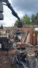 Crane claw sorts scrap metal at a Gabrovo junkyard