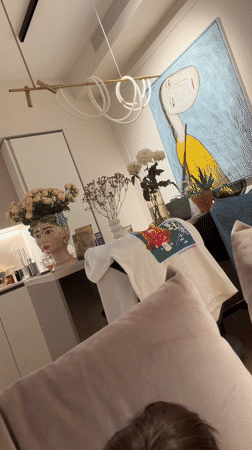 Woman relaxes with facial mask, dog on Moscow couch