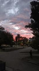 Dramatic sunset illuminates evening park activities in Villa Domínico
