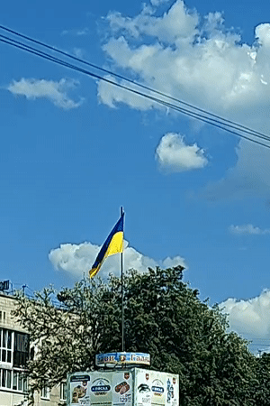Ukrainian flag waves on sunny day in Hadiach