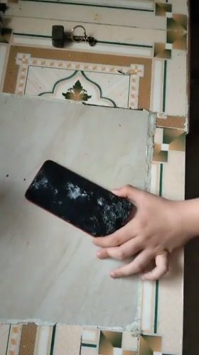 Child destroys cracked smartphone with wooden pestle in Puttaparthi