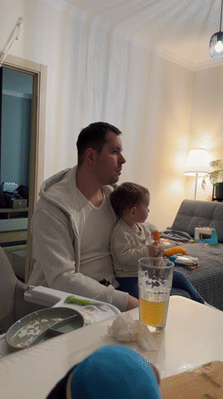Father and child share pizza dinner in Akulovo
