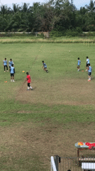 Soccer team practices on Indonesian fields under cloudy skies