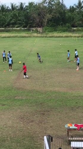 Soccer team practices on Indonesian fields under cloudy skies