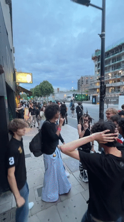 Crowd gathers outside Revolver London venue on summer evening