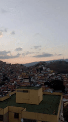 Evening cityscape documented in Caracas showing hillside residential areas