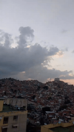 Evening cityscape documented in Caracas showing hillside residential areas