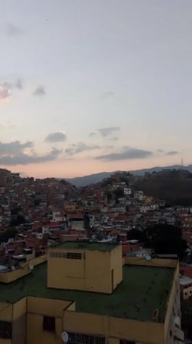 Evening cityscape documented in Caracas showing hillside residential areas
