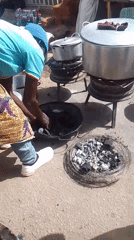 Woman cooks outdoors with charcoal grills in Bukuru Nigeria