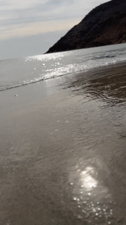 Evening waves roll onto Juan Griego beach under cloudy skies