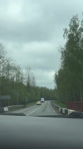 Vehicle crosses rural bridge as ambulance approaches in Russia