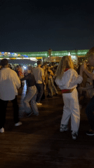 Nighttime dancing by a illuminated Moscow bridge