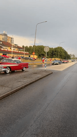 Classic car parade through rainy Falkenberg streets