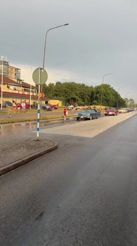 Classic car parade through rainy Falkenberg streets