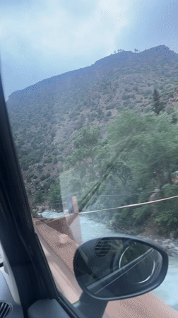 Passenger records roadside view while traveling through Tazitount, Morocco