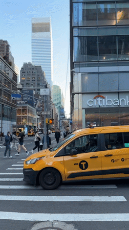 NYC taxi blocks crosswalk as pedestrians navigate street