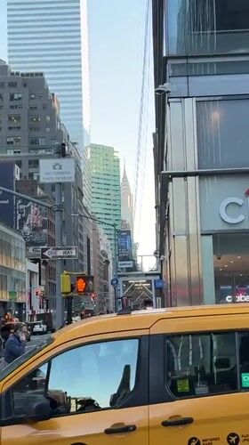 NYC taxi blocks crosswalk as pedestrians navigate street