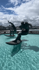 Tourist documents bronze surfer fountain in A Coruña, Spain